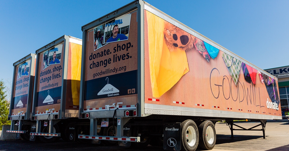 Three Semi-Trailers Parked in a Row with Goodwill Graphics